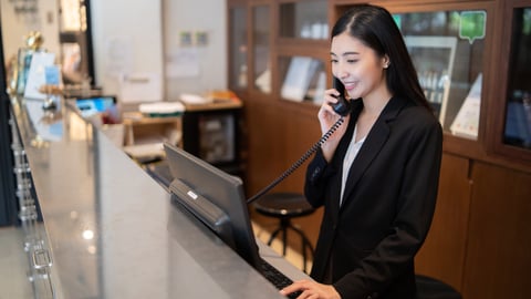 hotel receptionist talking on phone