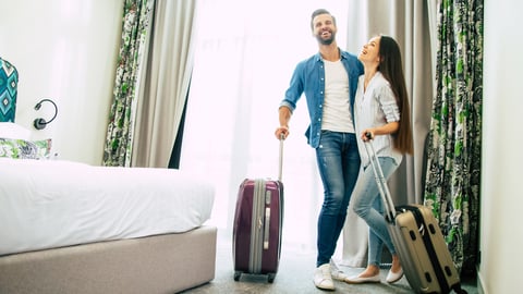 man and woman laughing while in hotel room