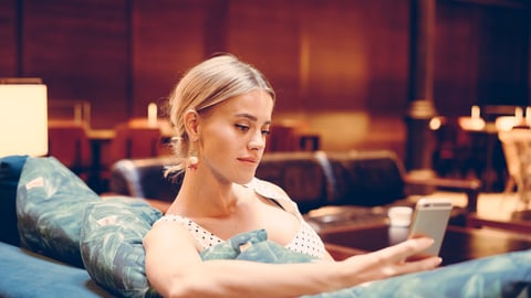 woman looking at her phone in a hotel lobby