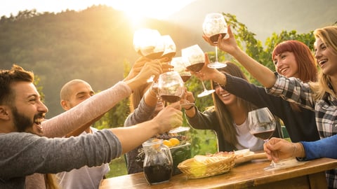 a group of people standing around a table with food