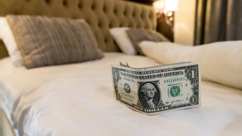 hotel bedroom with cash tip for house keeping