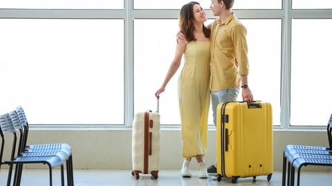 young couple in airport traveling with luggage