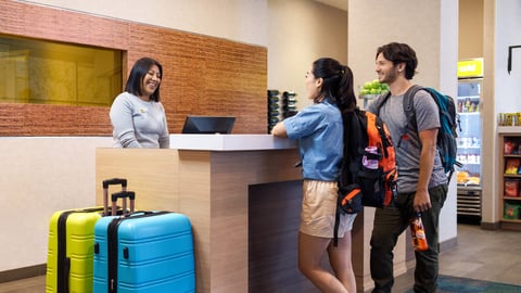 couple checking in at hotel front desk