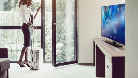 woman casting phone to TV in hotel room using airplay