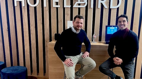 hotelbird lobby with two men sitting in front of the logo