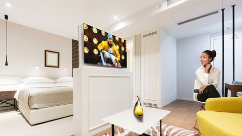 woman watching TV in hotel room