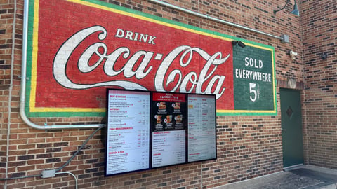 digital menu board on a brick wall