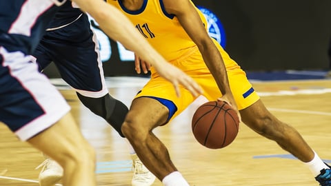 The basketball ball is on the basketball player's hand; Shutterstock ID 1475786261