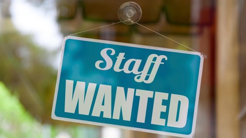Close-up on a blue open sign in the window of a shop displaying the message: Staff wanted.; Shutterstock ID 1760558399
