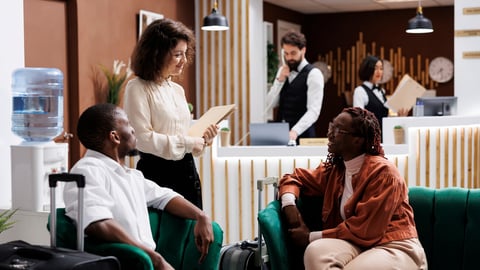 Manager asking guests about service, trying to provide warm welcome and modern spacious rooms. Hotel concierge talking to people in lounge area lobby, checking staff hospitality.; Shutterstock ID 2328045905