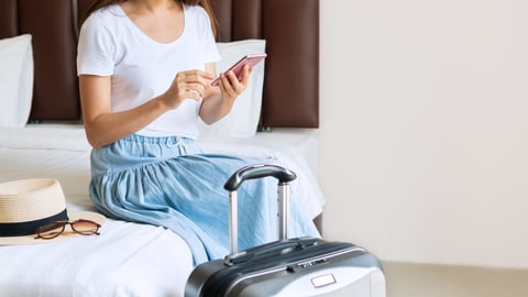 woman on phone while in hotel room