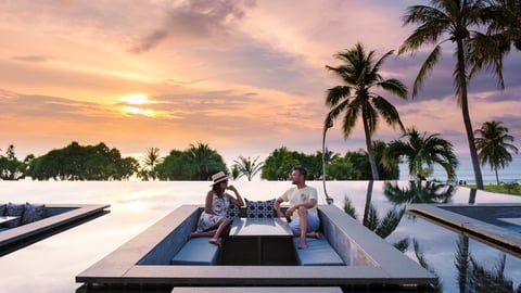 couple watching sunset at hotel beach