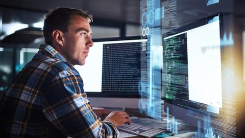 data analysis coding guy in front of pc screens