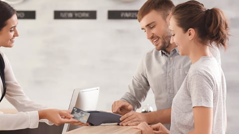 front desk agent at hotel taking credit card payment