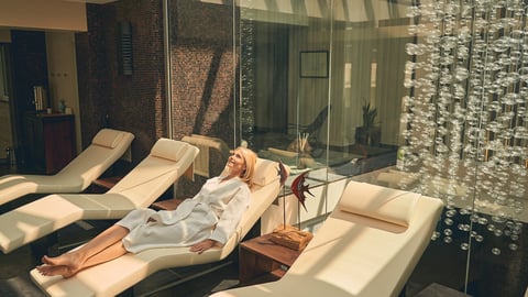 Top view of charming female wearing white bathrobe while lying on the sun bed in spa resort hotel; Shutterstock ID 1788966920