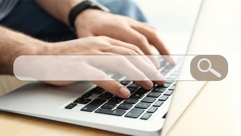 Search bar of internet browser and man working on modern laptop at table indoors, closeup; Shutterstock ID 1724609503