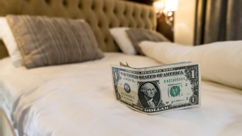 paying us money dollar on white bed in hotel. tips left on the bed for the maid of the hotel room. Tips at the bed for the housekeeper in hotel.; Shutterstock ID 1485877394