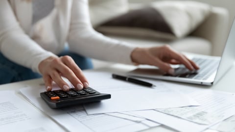 Close up of woman busy paying bills online on computer calculating household finances or taxes on machine, female manage home family expenditures, using calculator, make payment on laptop; Shutterstock ID 1716917581