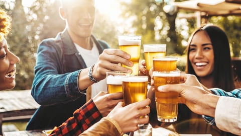 Happy friends cheering beer glasses at brewery pub garden - Group of young people enjoying happy hour sitting at bar table - Life style concept with guys and girls having dinner party together; Shutterstock ID 2258948725