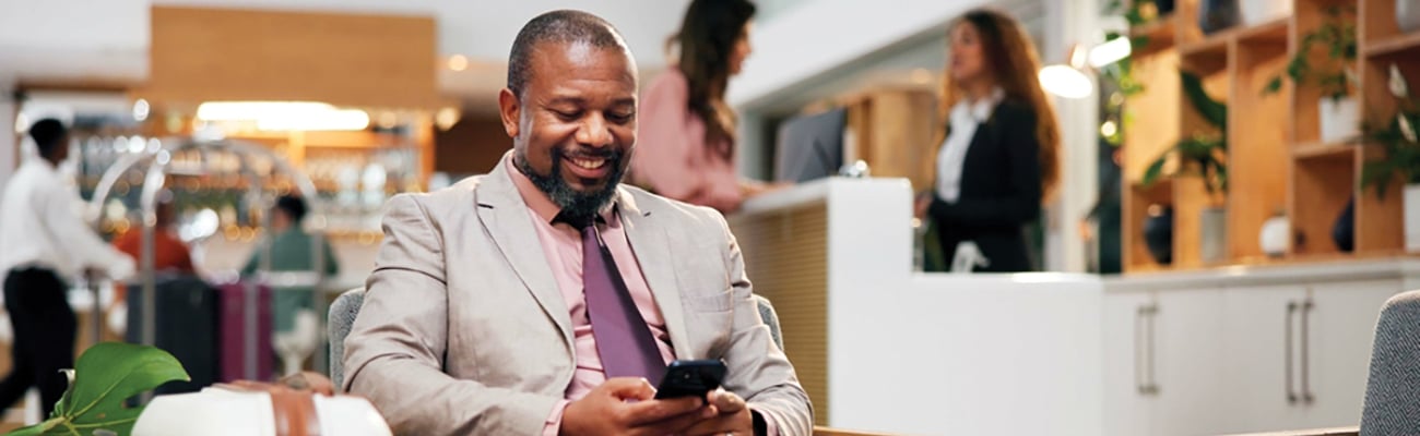 man looking at smartphone in hotel lobby