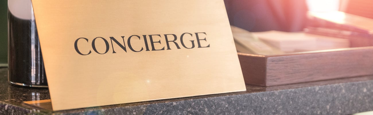 Concierge service desk counter with happy employee staff receptionist working in front of hotel with tourist guest business customer.; Shutterstock ID 1246604926