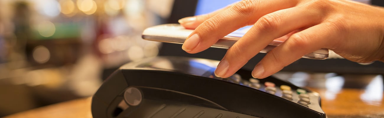 Woman paying with NFC technology on mobile phone, restaurant, cafe, bar; Shutterstock ID 159873416