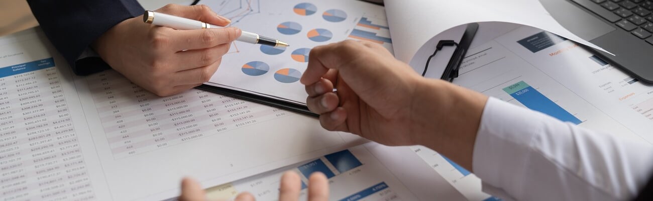 Businessman and woman discussing commercial real estate sector faces risks as financial buy used laptopcalculator and chart in the office.; Shutterstock ID 2497374541