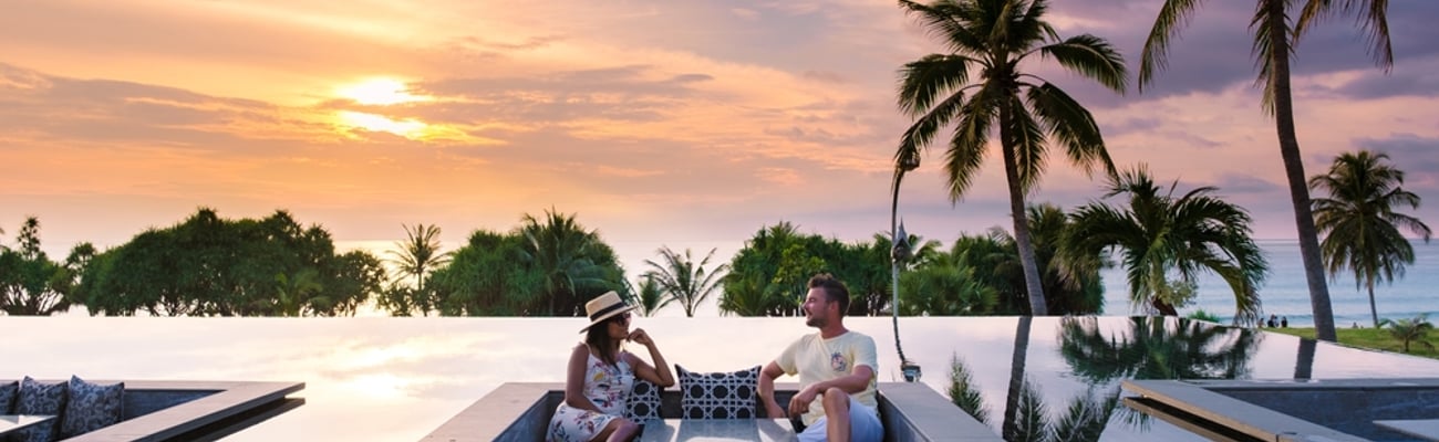 couple watching sunset at hotel beach