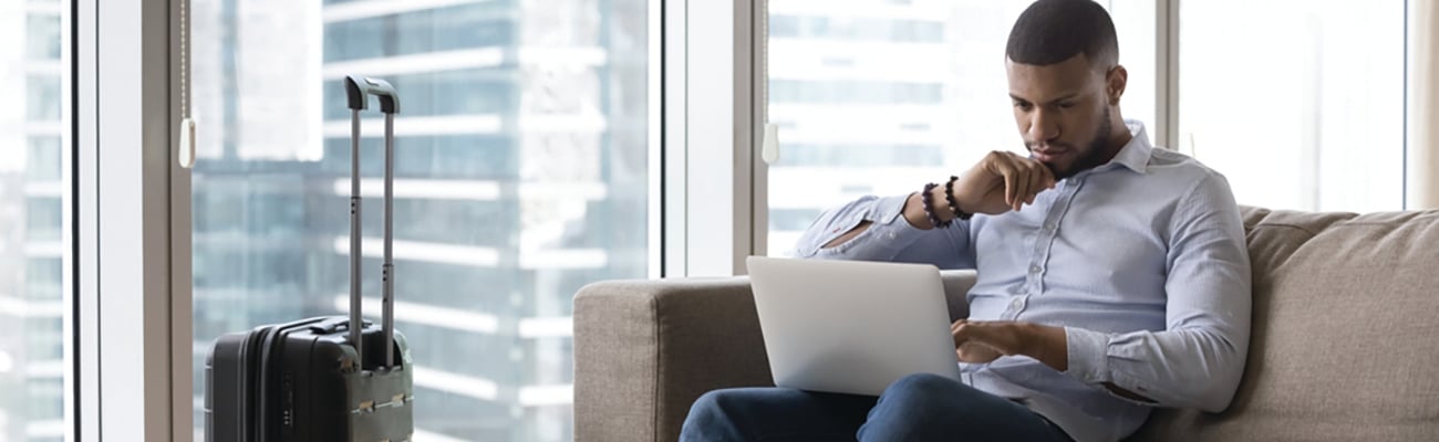 man on laptop in hotel guestroom