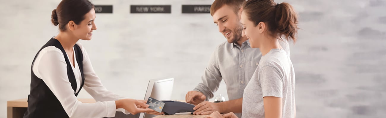 front desk agent at hotel taking credit card payment