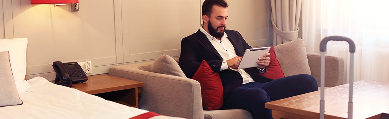 Man on tablet in hotel room