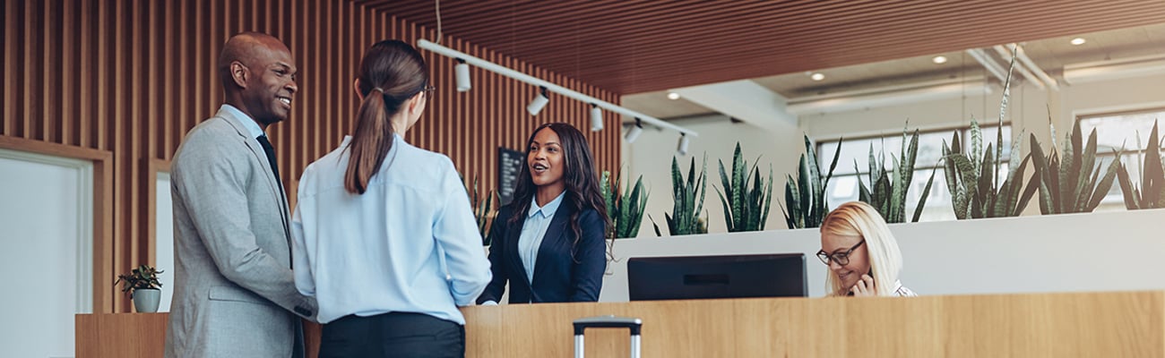 hotel staff greeting guests at front desk