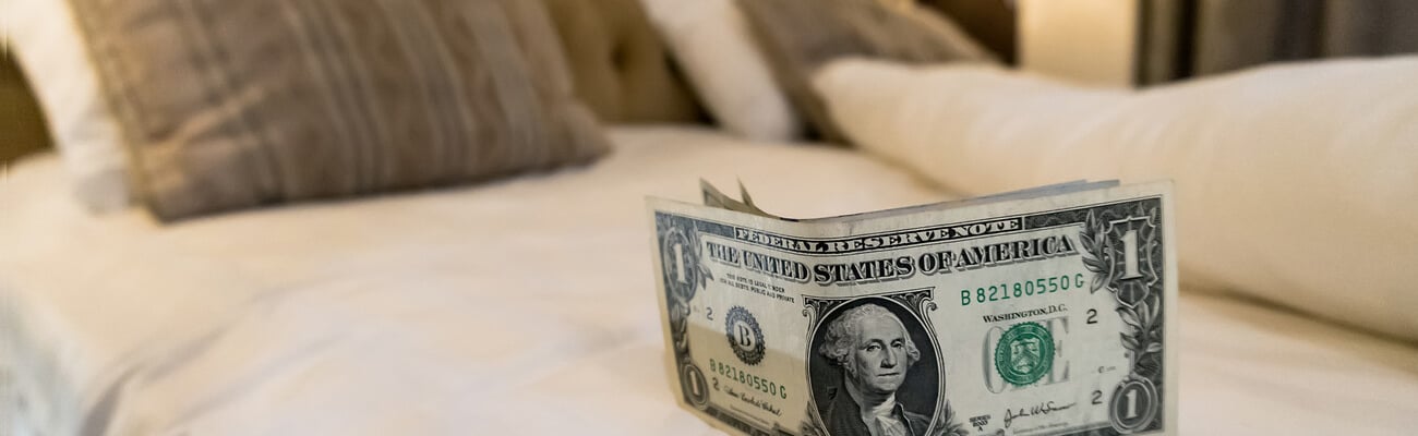 paying us money dollar on white bed in hotel. tips left on the bed for the maid of the hotel room. Tips at the bed for the housekeeper in hotel.; Shutterstock ID 1485877394