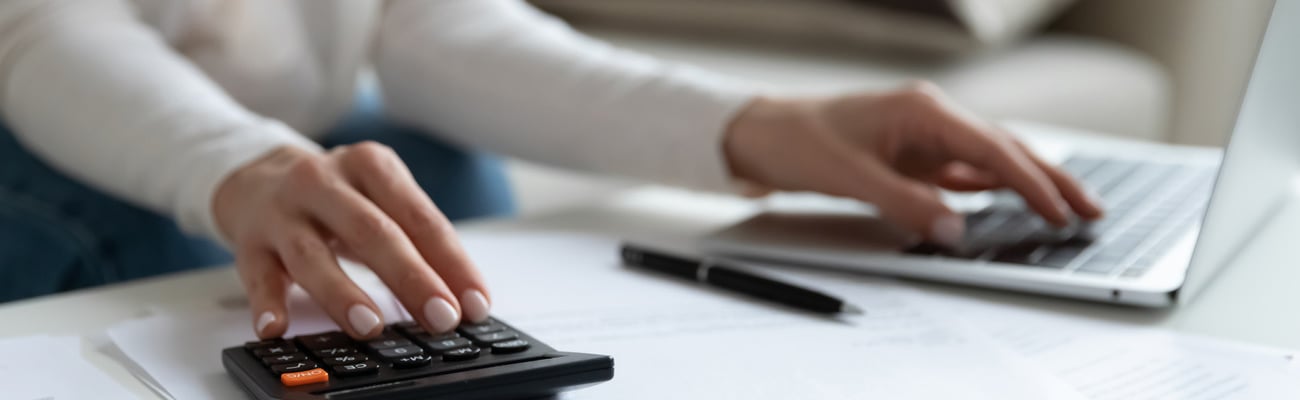 Close up of woman busy paying bills online on computer calculating household finances or taxes on machine, female manage home family expenditures, using calculator, make payment on laptop; Shutterstock ID 1716917581