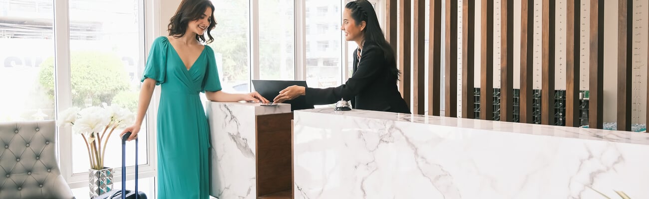 Asian girl receptionist and Caucasian woman traveler checking or checkout in hotel; Shutterstock ID 1964198212