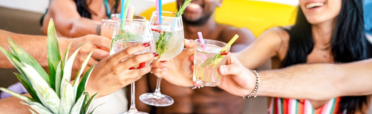 Trendy people toasting fancy cocktails at boat party trip - Young millenial friends having fun on luxury vacation - Travel life style concept with vacationer sharing aperitif drink with tropical fruit; Shutterstock ID 2292035723