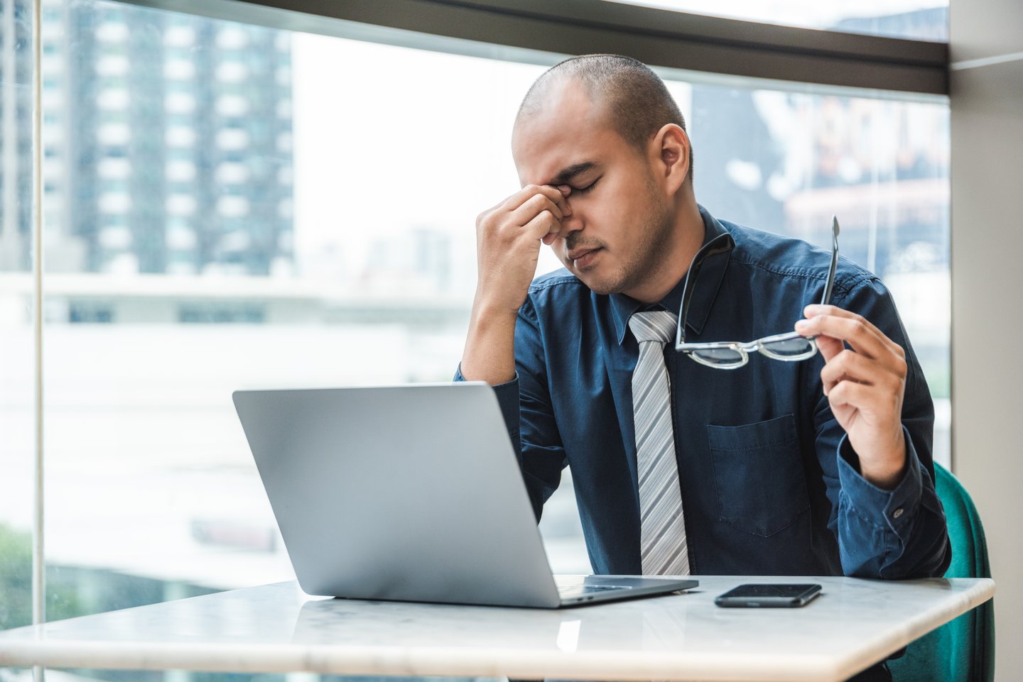 a man sitting at a table using a laptop