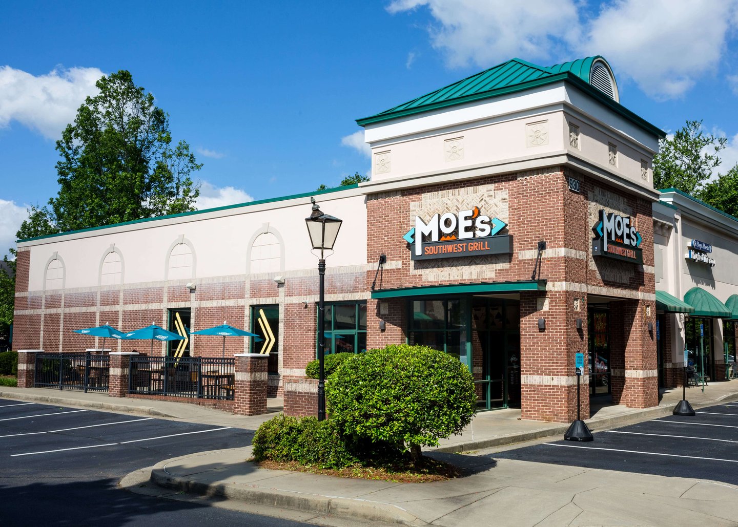 a large brick building with a clock on the side of a road