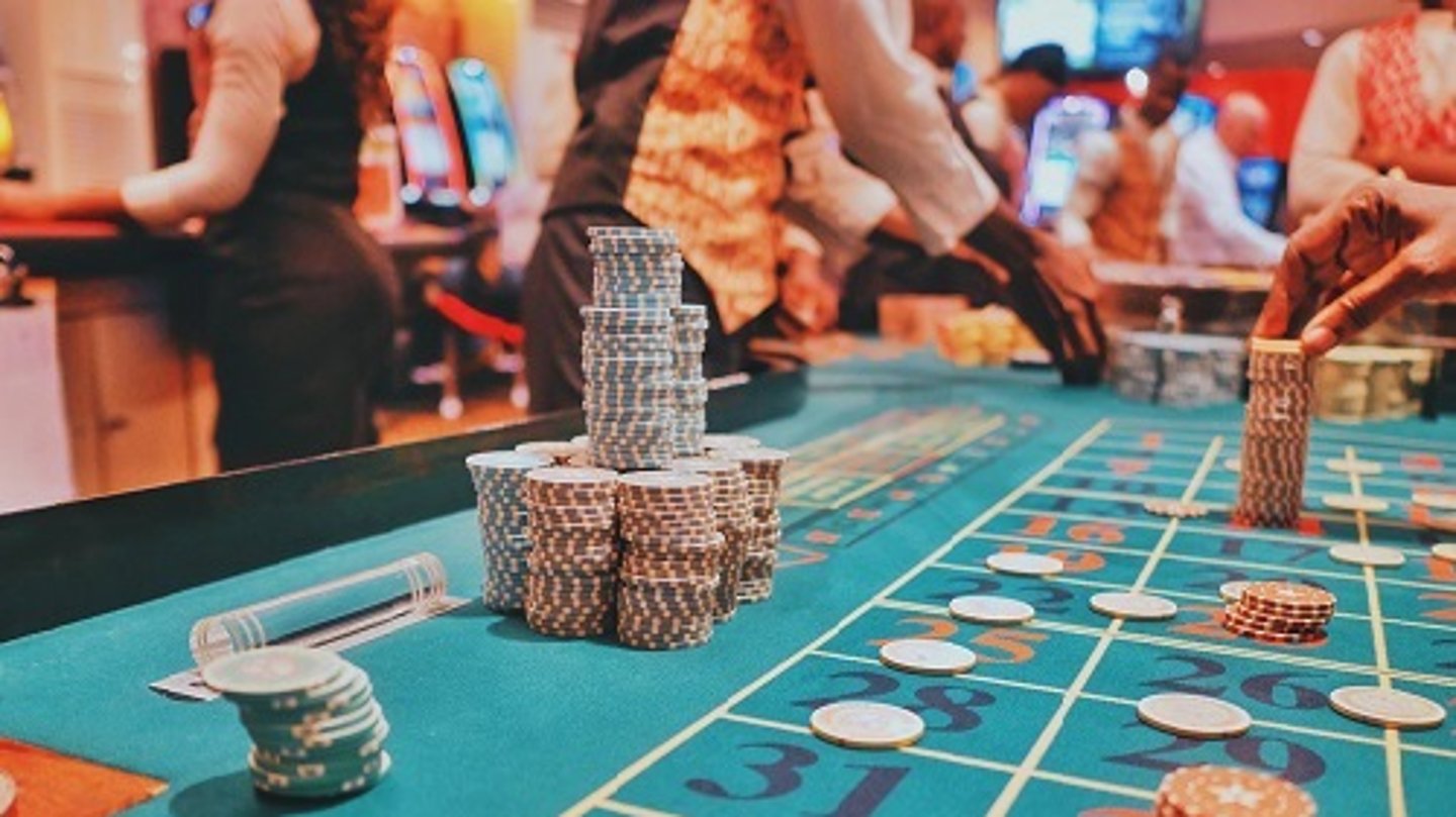 a group of people sitting at a gaming table in a casino