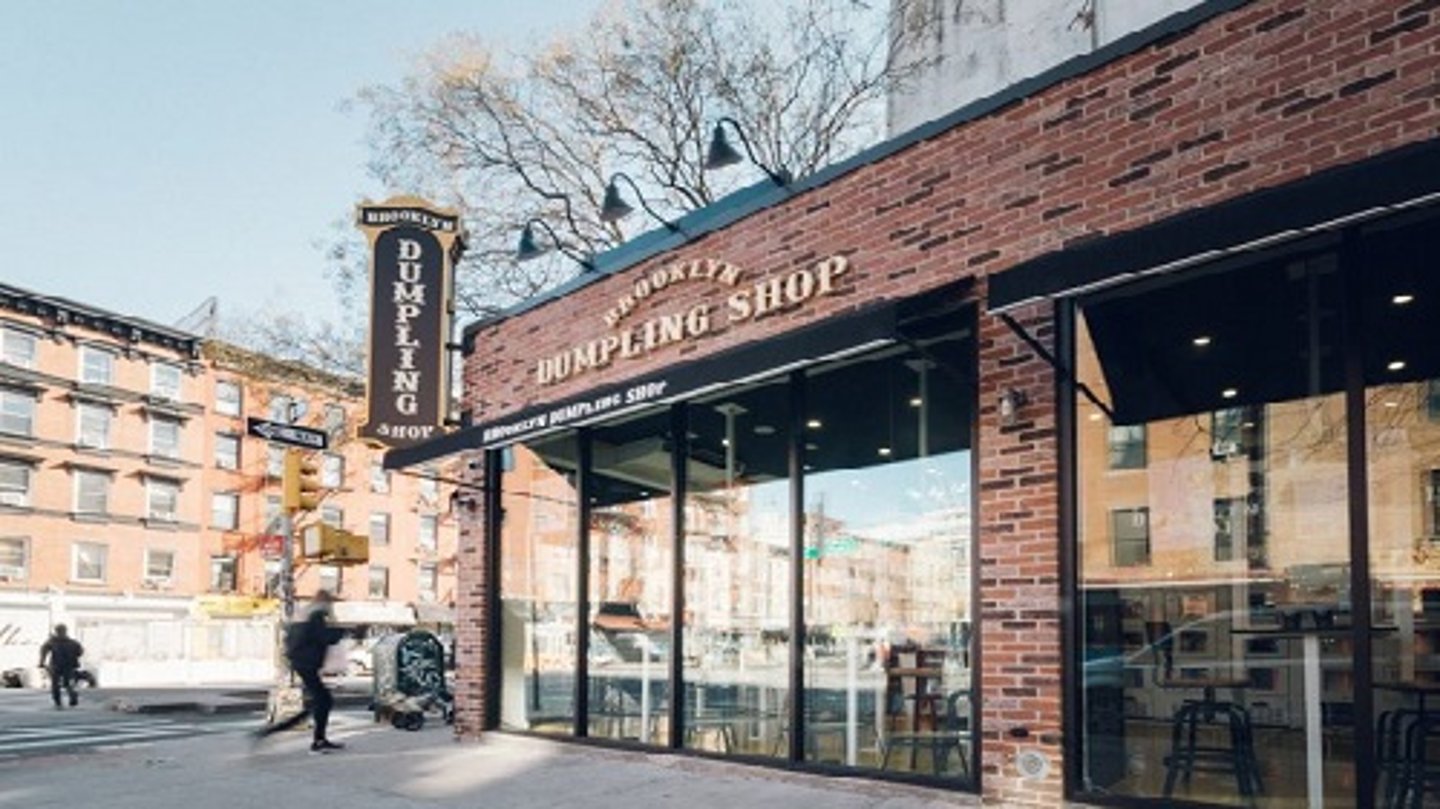 a large brick building with a store on a city street