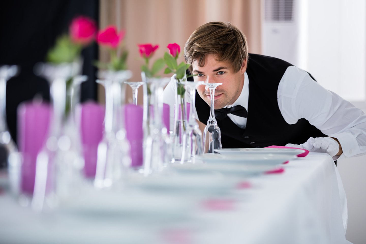 Hotel waiter working on tables