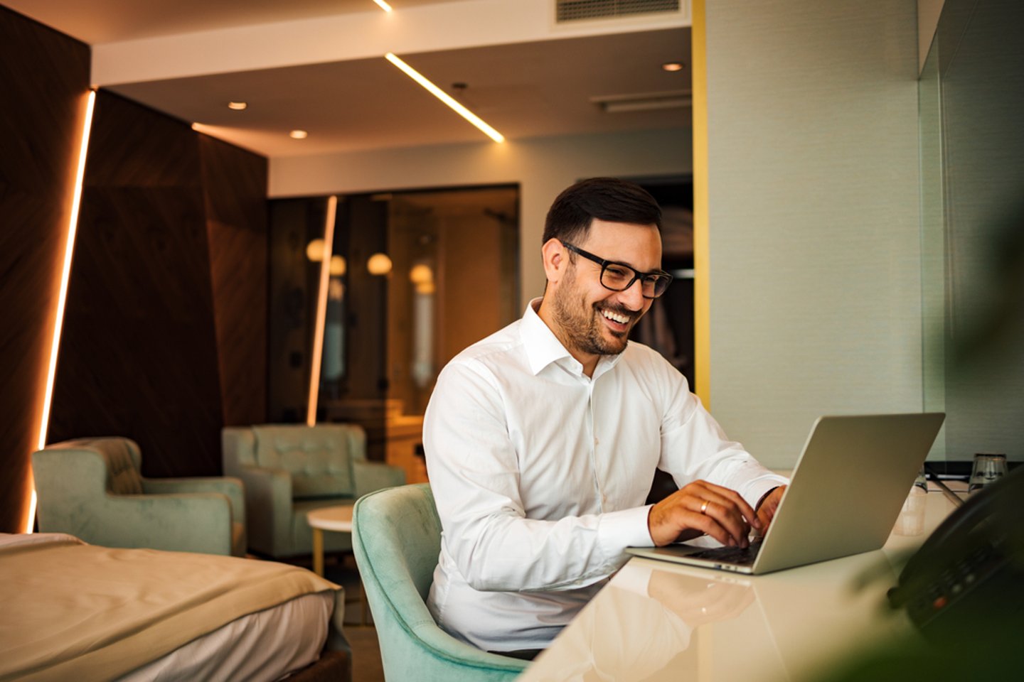 Man working on laptop in hotel room