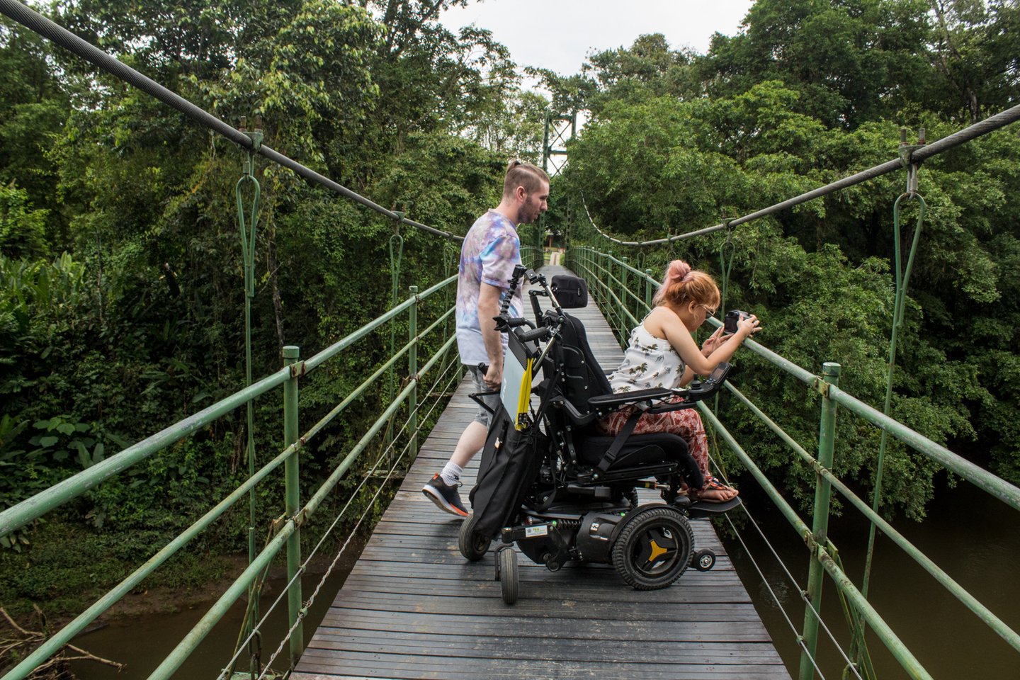 Woman in wheelchair on a rope bridge