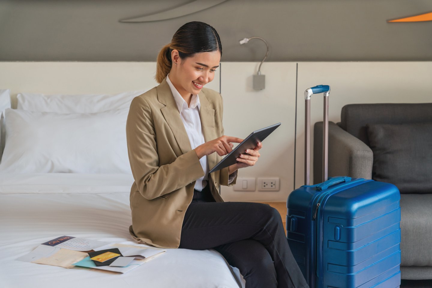 a woman sitting on a bed next to her suitcase