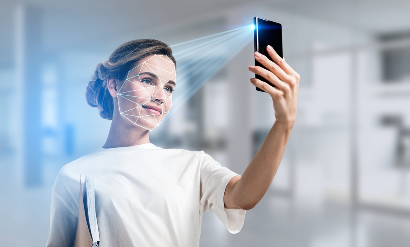 a woman holding up a camera for biometric face scans