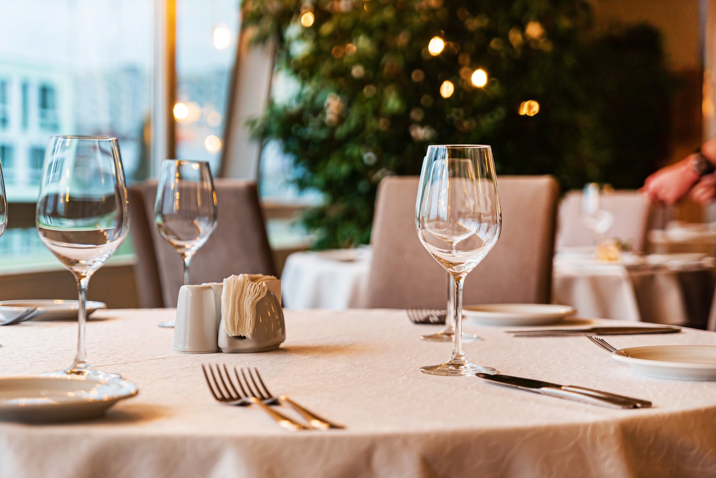 a person sitting at a table with wine glasses