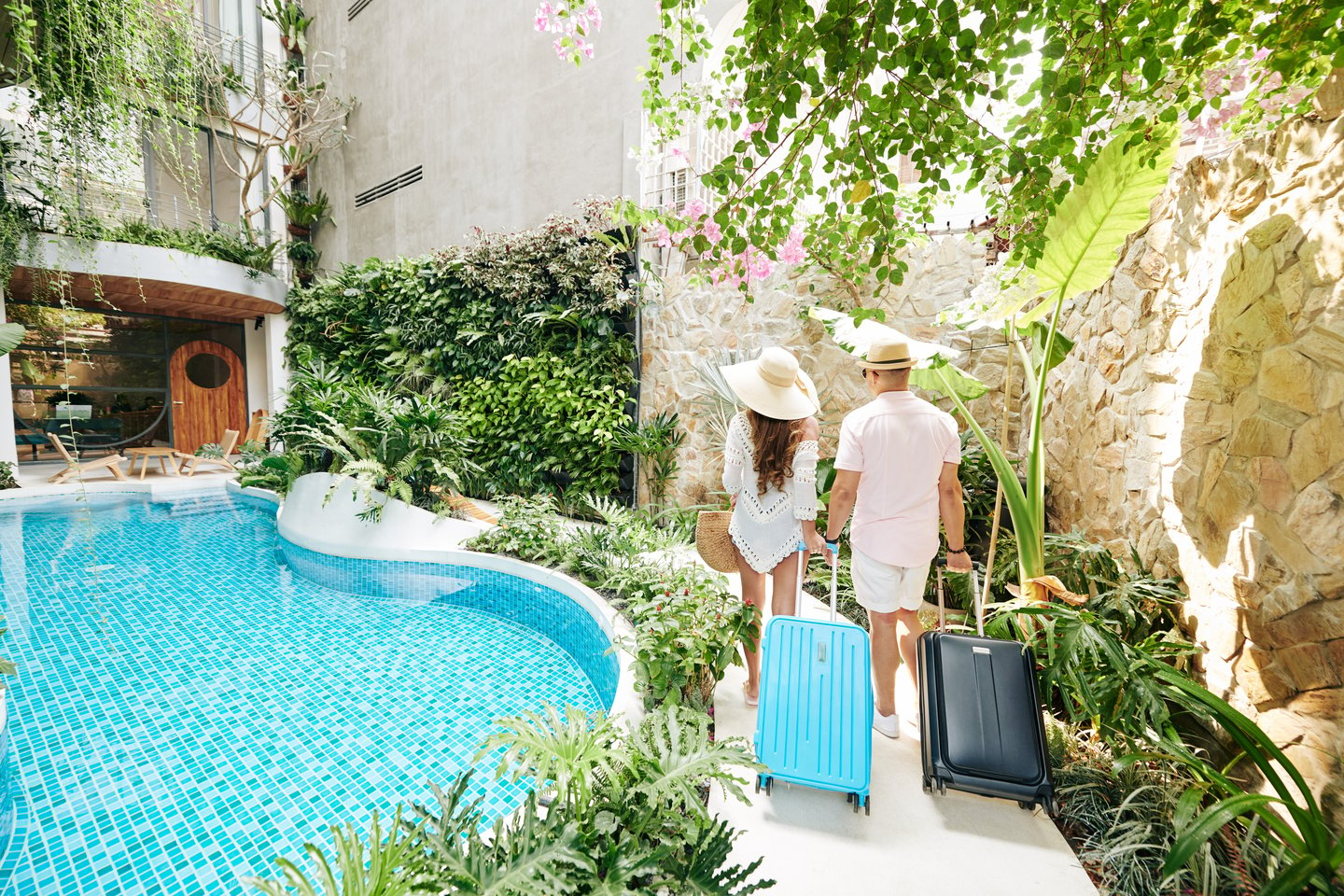 a man and woman walking next to a pool at a resort