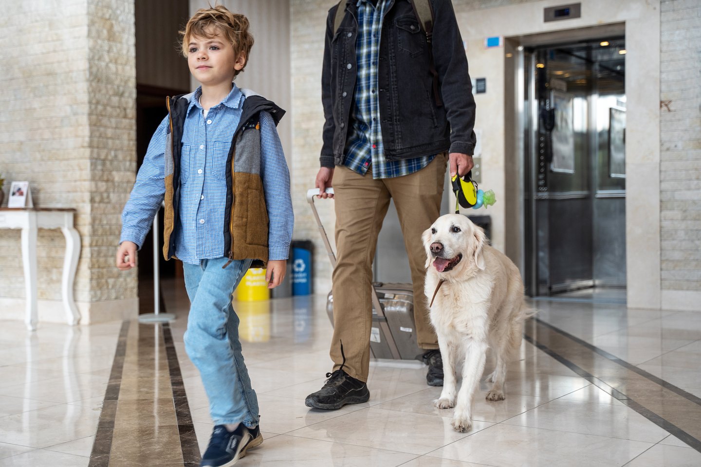 hotel guests walking into lobby with family dog