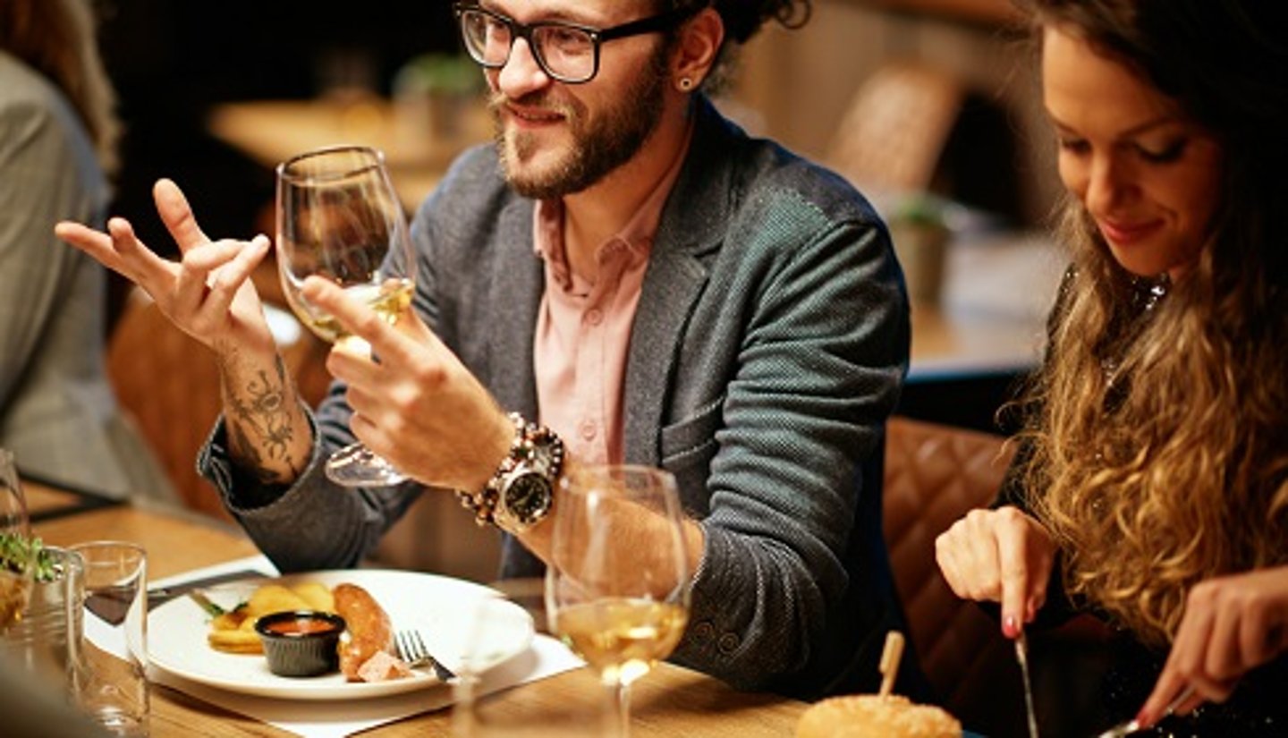 hipster guy with man bun drinking wine