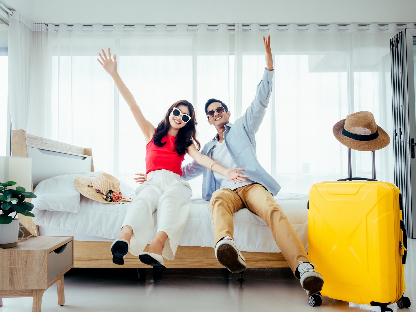 two people falling happily onto a hotel bed